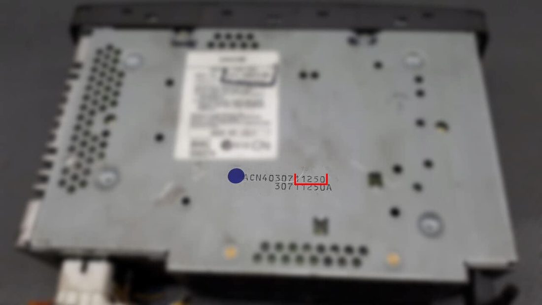 The serial number plate under a Jaguar sat nav unit, with the last five digits boxed